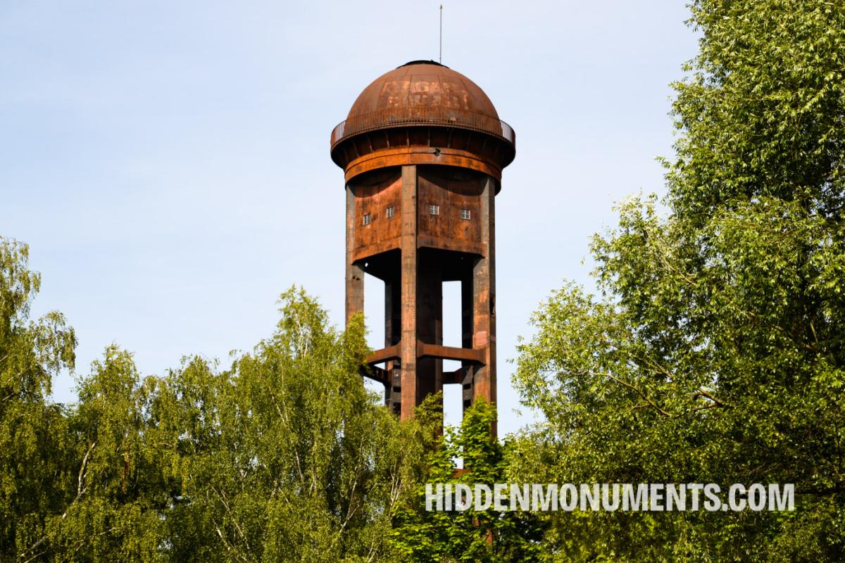 A 50-meter-high water tower rises from the ground between the former Tempelhof railway yard tracks in Berlin. 